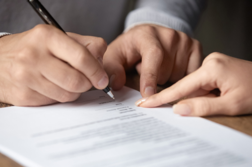 Image of an employee signing a contract | Confidential Documents