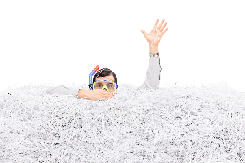 Man diving in a pile of shredded paper isolated on white background